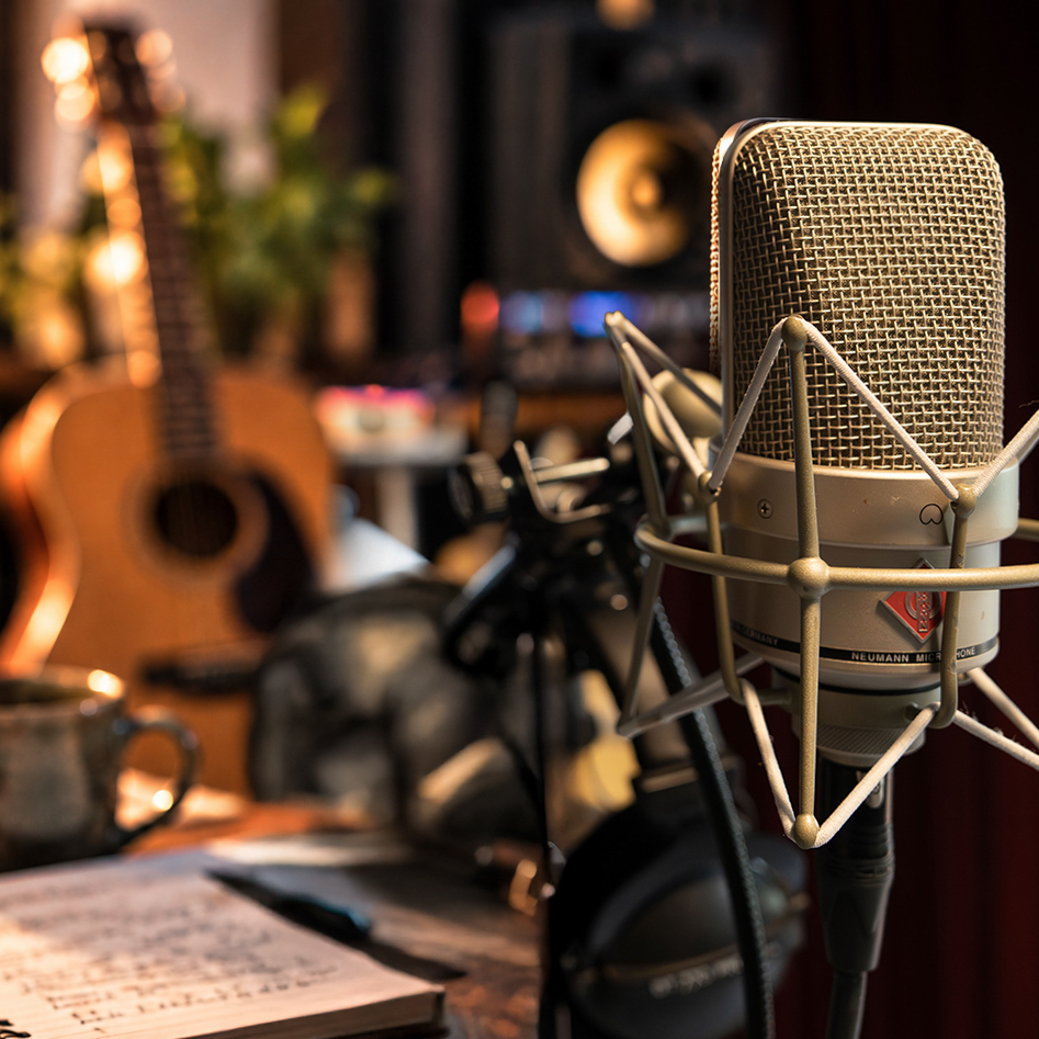 Mikrofon, Gitarre und Kopfhörer bei einer Musikproduktion